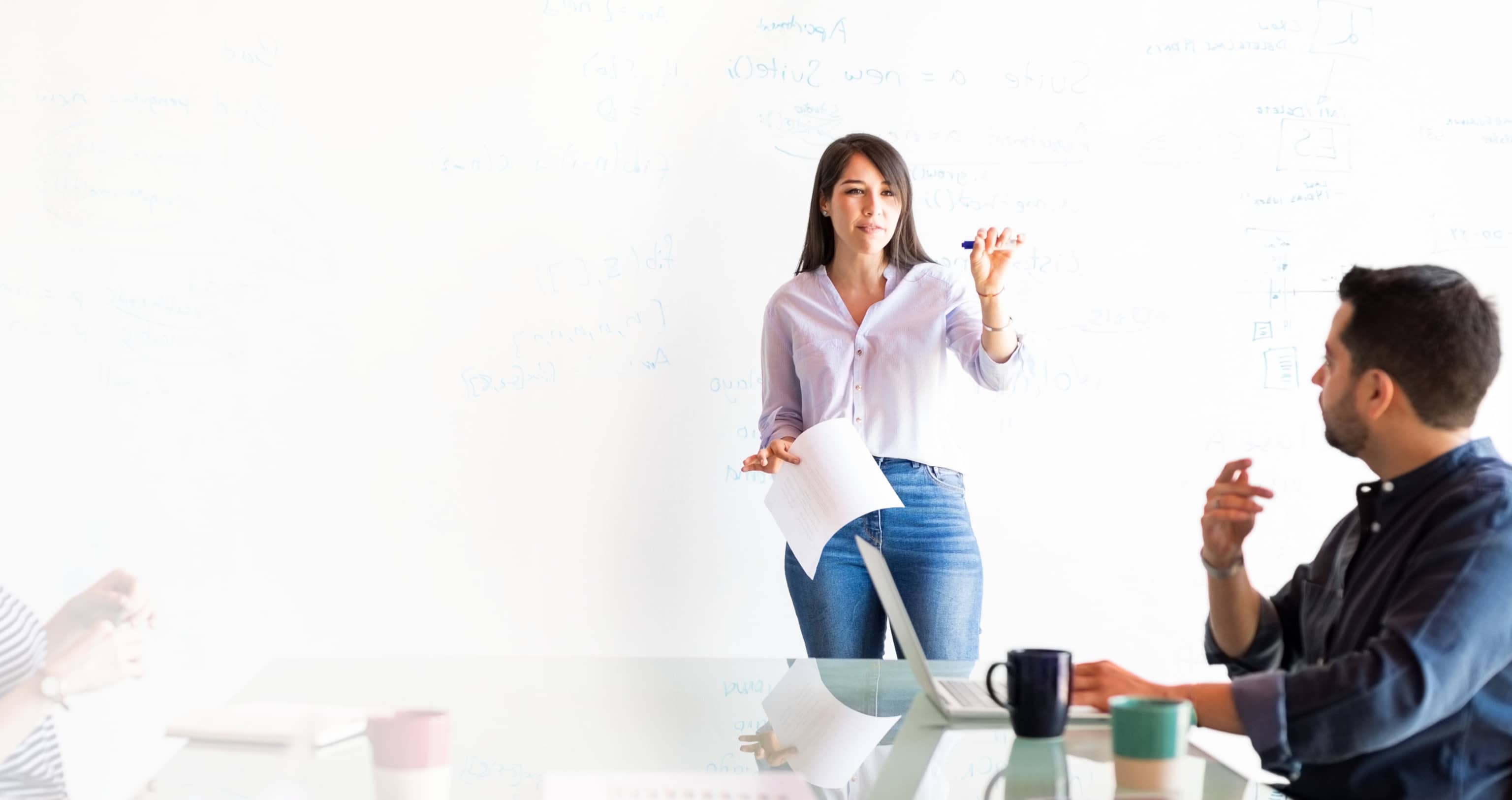 Woman presenting at whiteboard wall